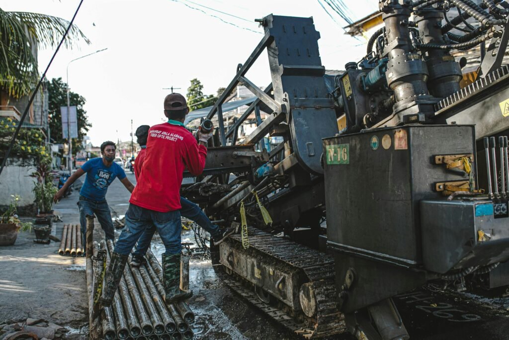 Urban scene of construction workers operating heavy machinery for street drilling.